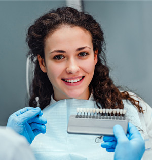 Dentist checking a custom-made dental crown to match the color of teeth in Worcester & Central, MA.